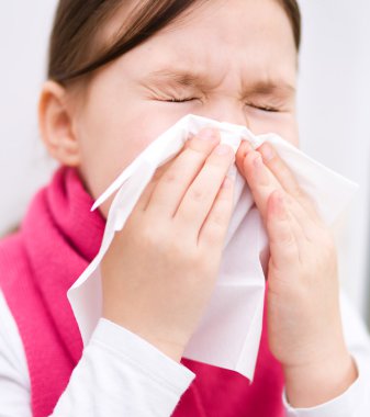 Kız burnunu siliyor.