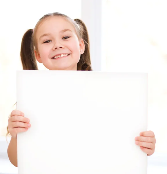 Menina bonito está segurando banner em branco — Fotografia de Stock