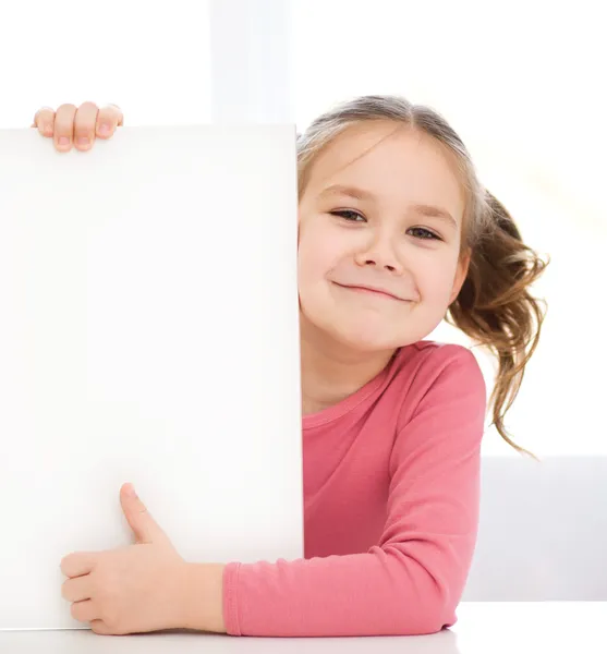 Menina bonito está segurando banner em branco — Fotografia de Stock