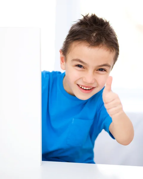 Lindo chico está sosteniendo banner en blanco — Foto de Stock