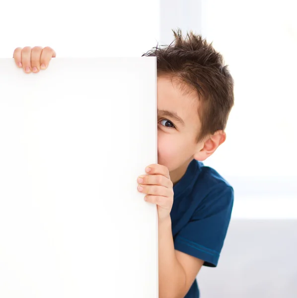 Lindo chico está sosteniendo banner en blanco — Foto de Stock