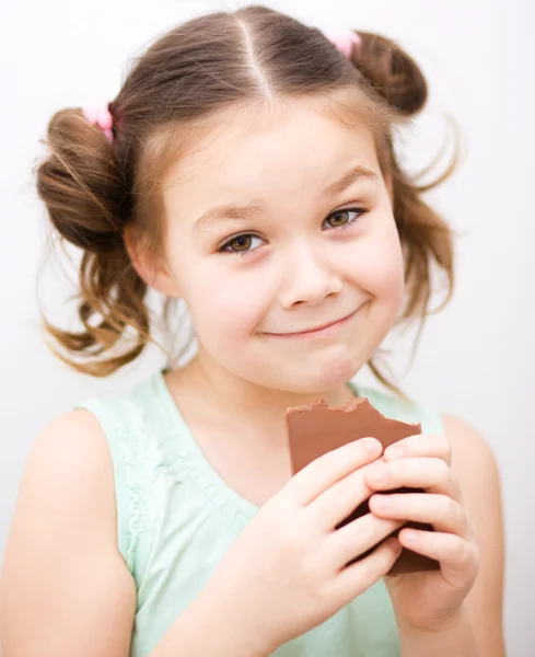 Cute girl is eating chocolate candy — Stock Photo, Image