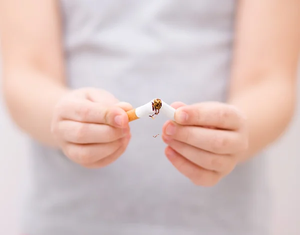 Jovem está quebrando um cigarro — Fotografia de Stock