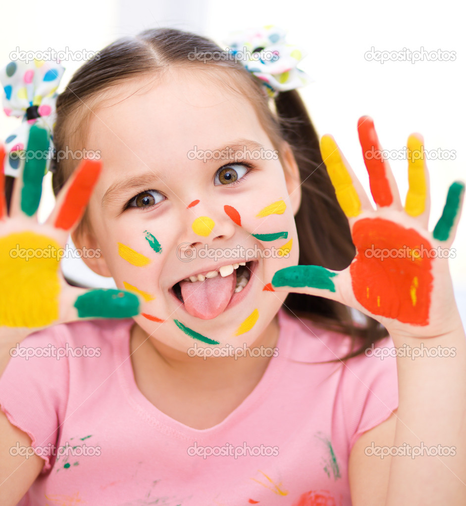 Portrait of a cute girl playing with paints