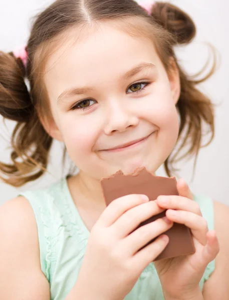 Cute girl is eating chocolate candy — Stock Photo, Image