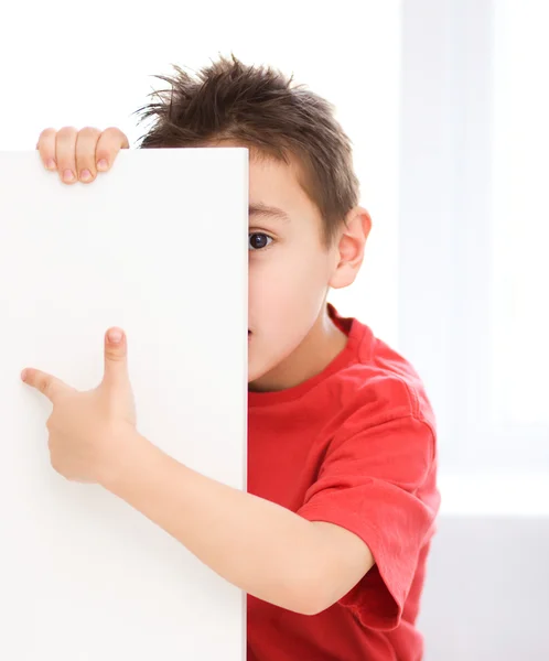 Lindo chico está sosteniendo banner en blanco — Foto de Stock