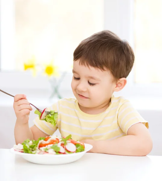 Милий маленький хлопчик їсть овочевий салат — стокове фото