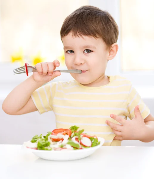 Schattige kleine jongen is het eten van fruit salade — Stockfoto