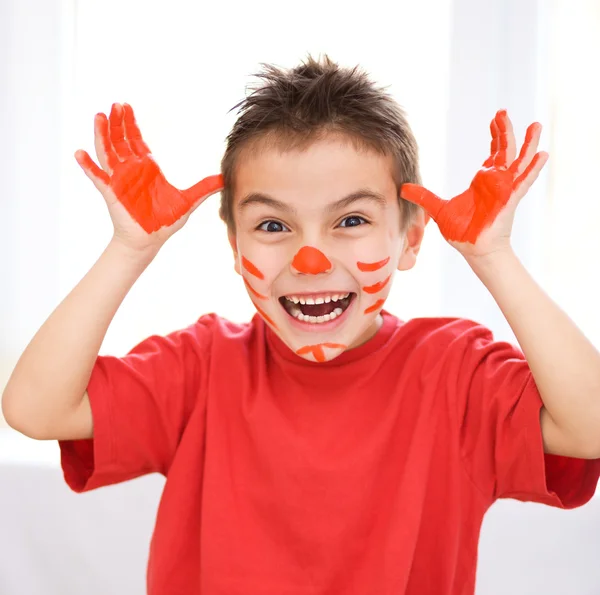 Porträt eines süßen Jungen, der mit Farben spielt — Stockfoto