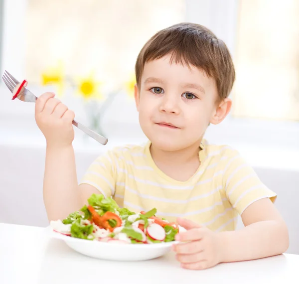 Schattige kleine jongen is het eten van fruit salade — Stockfoto