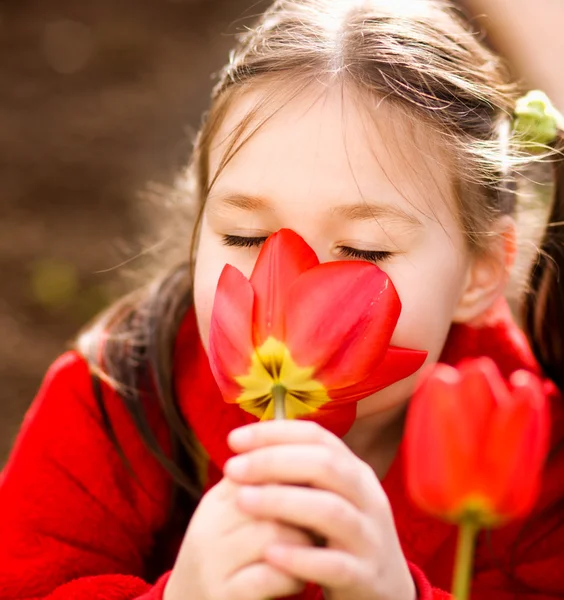 小さな女の子の臭いがする花アウトドア — ストック写真