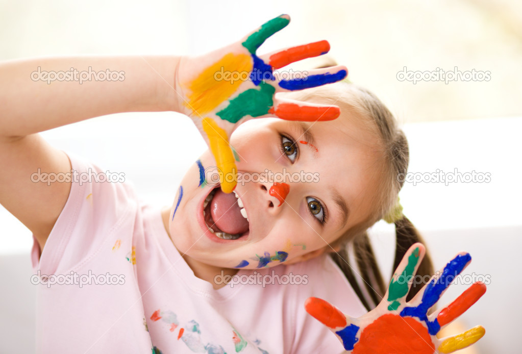 Portrait of a cute girl playing with paints