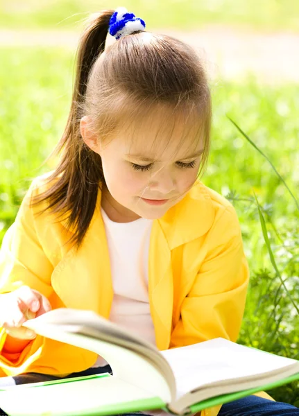 La bambina sta leggendo un libro all'aperto — Foto Stock