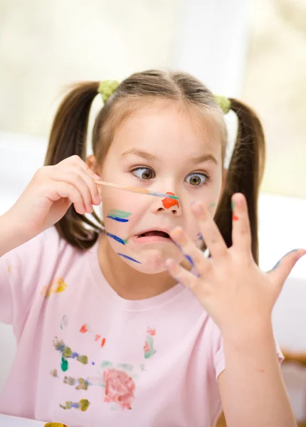 Egy aranyos lány játék festékek a portréja — Stock Fotó