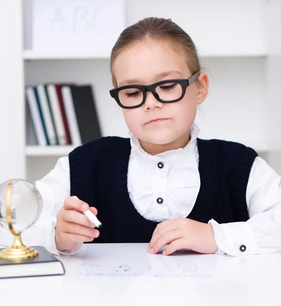 Cute girl writes a pen — Stock Photo, Image