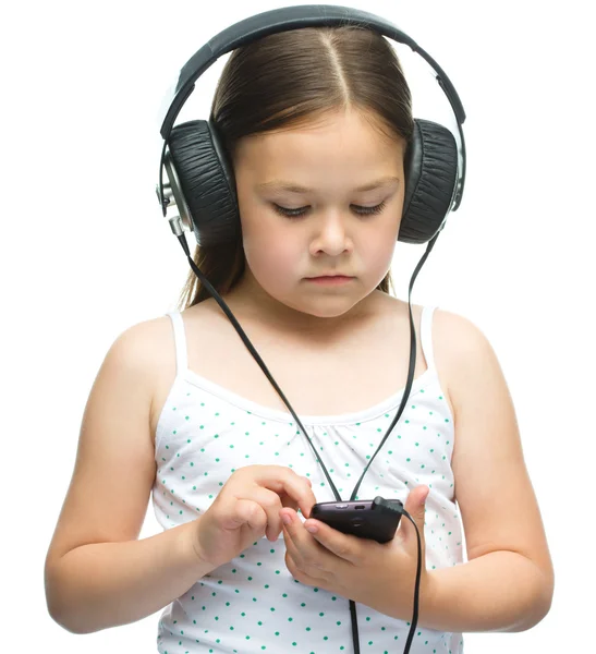 लहान मुलगी हेडफोन्स वापरून संगीत आनंद घेत आहे — स्टॉक फोटो, इमेज
