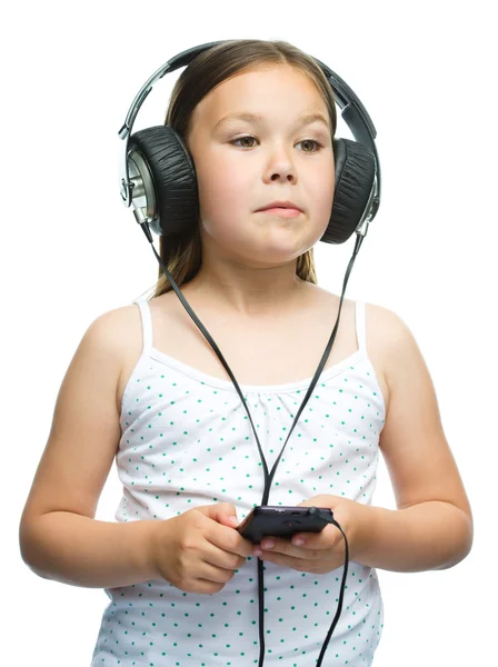 Lilla tjejen njuter av musik med hörlurar — Stockfoto