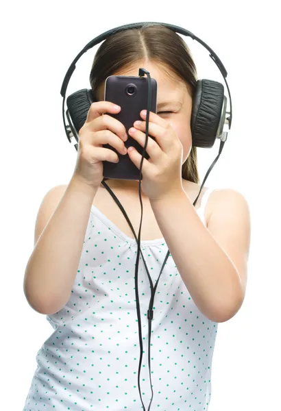 Niña está disfrutando de la música usando auriculares —  Fotos de Stock