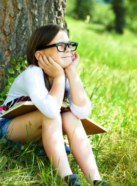 küçük kız açık havada bir kitap okuma