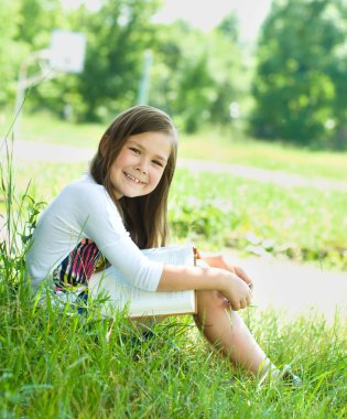 küçük kız açık havada bir kitap okuma