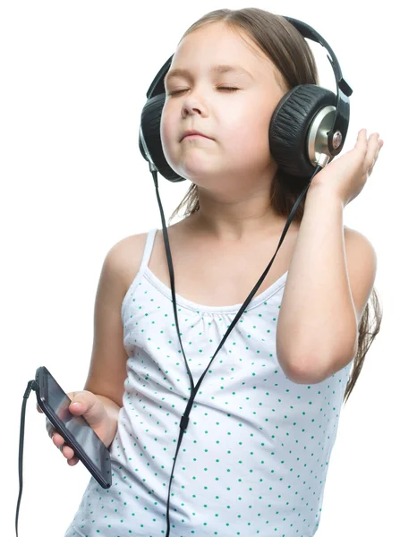 Niña está disfrutando de la música usando auriculares — Foto de Stock