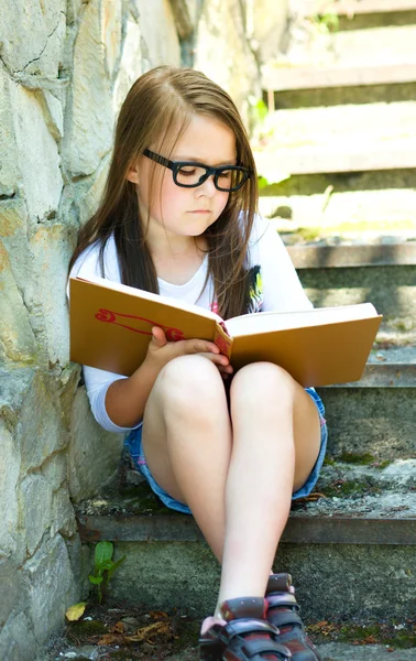 Cute girl is reading book — Stock Photo, Image