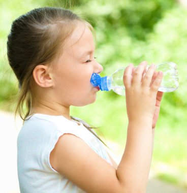 sevimli kız suyu plastik şişeden içer.