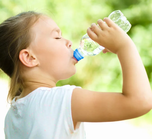 Милая девушка пьет воду из пластиковой бутылки — стоковое фото