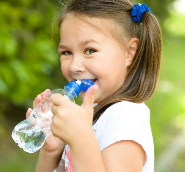 Cute girl drinks water from a plastic bottle — Stock Photo, Image