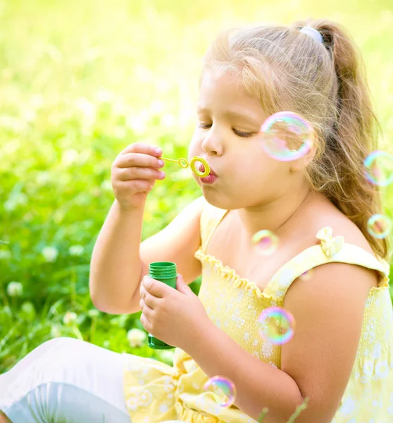 Little girl blowing soap bubbles — Stock Photo, Image