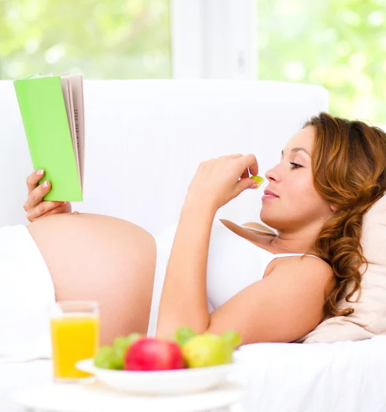 Zwangere vrouw met boek — Stockfoto