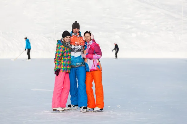 Young people, friends, winter ice-skating on the frozen lake — Stock fotografie