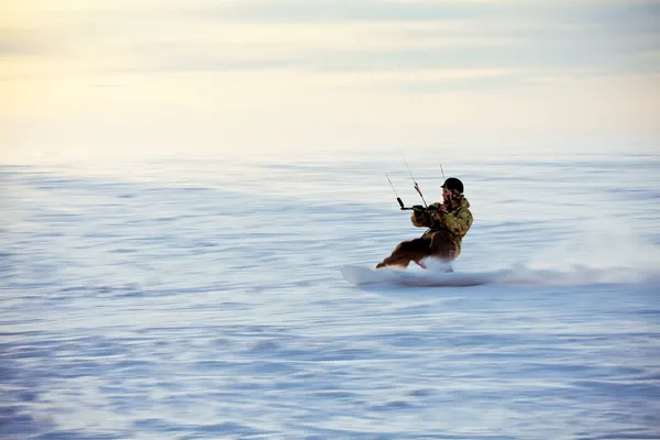 Vliegeren op een snowboard op een bevroren meer — Stockfoto