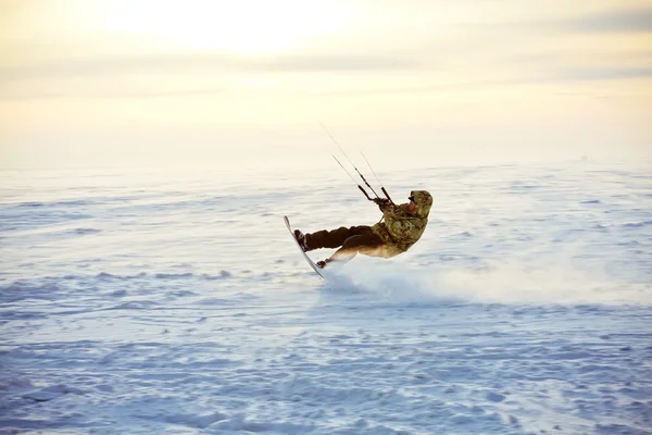 Vliegeren op een snowboard op een bevroren meer — Stockfoto