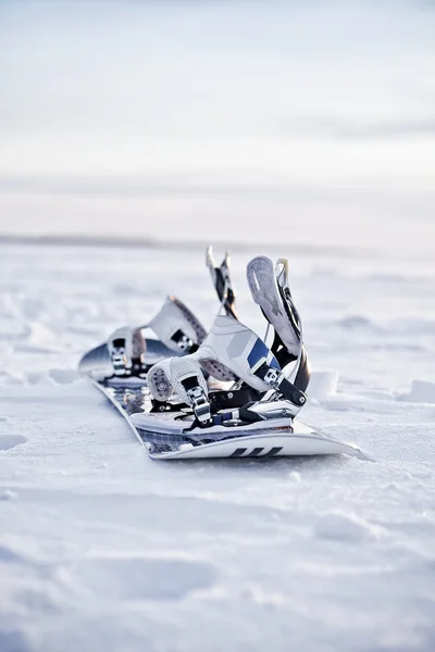 Karda gün batımında snowboard