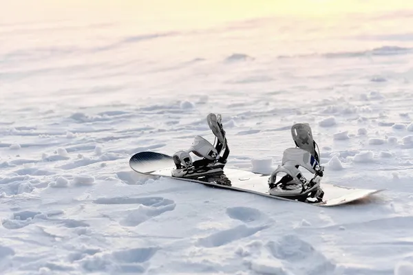 Сноуборд в снегу на закате — стоковое фото