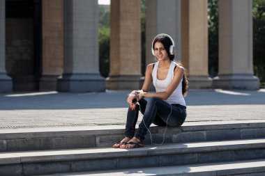 üniversite yakınında merdivenlerde oturan genç bir Bayan dinle