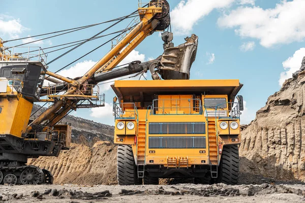 Großer Baggerkipper. Großer gelber Bergbaulastwagen auf der Baustelle. Kohle in Karosseriewagen verladen. Produktion nützlicher Mineralien. Bergbaumaschinen für den Transport von Kohle aus der Tagebauproduktion — Stockfoto