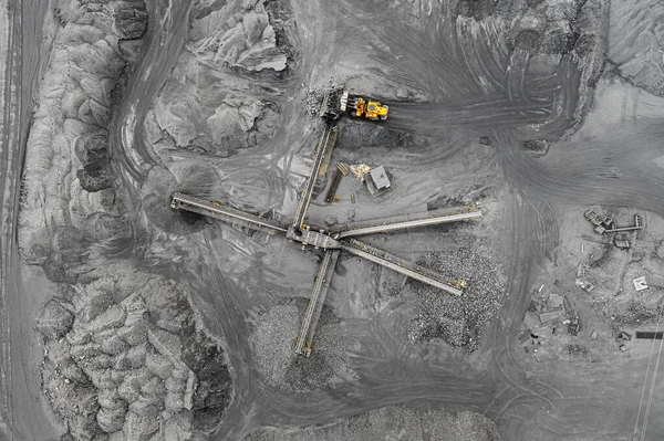 Открытая шахта, сортировка пород. Добыча угля. Бульдозер сортирует уголь. Добывающая промышленность, антрацит. Комплекс сокрушительного марширования. Угольная промышленность . Стоковое Фото