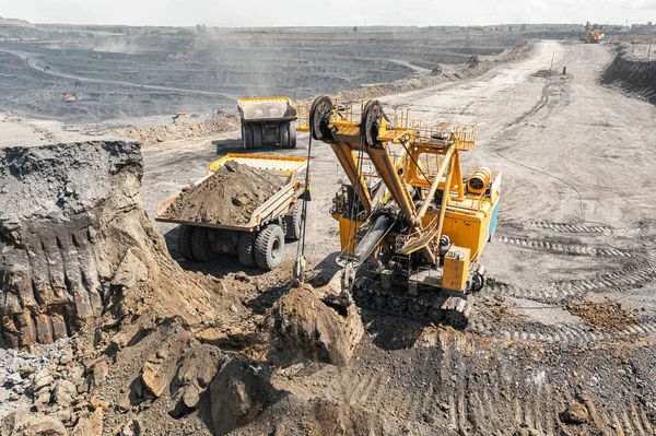 Panoramatický letecký pohled na uhelný důl. Otevřený důlní průmysl, velký žlutý důlní vůz pro uhelný lom. Těžba antracitu pod širým nebem. Dno těžby uhlí otevřenou cestou. Skála naložená v nákladních automobilech — Stock fotografie