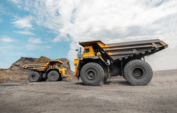 Egy nagy kőfejtő kamion. Egy nagy sárga bányászkocsi a munkahelyén. Szenet pakolok a karosszériába. Hasznos ásványi anyagok előállítása. Bányászgépjármű-bányászati gép szénszállításra a külszíni bányászatból — Stock Fotó