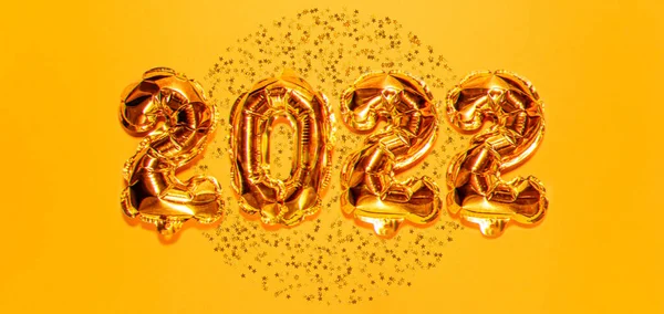 Šťastný Nový rok2022. Jasně zlaté balónky, novoroční balónky s třpytivými hvězdami na jasně žlutém pozadí. Vánoční a novoroční oslava. Zlaté fólie balónky 2022 dárková karta — Stock fotografie