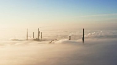 Sis içindeki fabrikanın havadan görünüşü. Sisin içinde uçmak, sisin içinde uçmak. Bitkinin üstündeki hava kamerası görüntüsü. Bulutların üzerinden güneşe doğru uç. Hava sisli, yukarıdan görünüyor. Kuşların bakış açısı