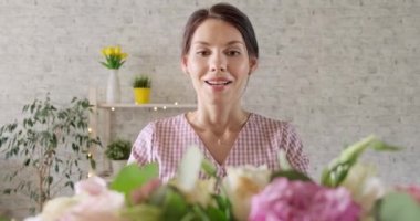 Gözleri kapalı genç bir kız bir buket çiçek alır. Kadın doğum günü hediyesini alır. Bir buket gül tutan mutlu kız