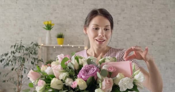 Fiatal lány csukott szemmel kap csokor virágot. A nő szülinapi ajándékot kap. Boldog lány kezében csokor rózsa — Stock videók