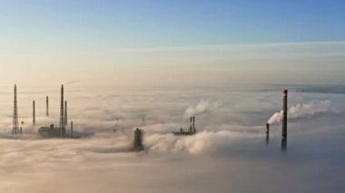 Sis içindeki fabrikanın havadan görünüşü. Sisin içinde uçmak, sisin içinde uçmak. Bitkinin üstündeki hava kamerası görüntüsü. Bulutların üzerinden güneşe doğru uç. Hava sisli, yukarıdan görünüyor. Kuşların bakış açısı