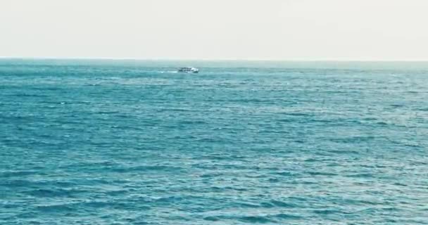 Μπλε τυρκουάζ θάλασσα με κύματα. Θέα στην ηλιόλουστη μέρα στον ωκεανό. Η επιφάνεια του νερού υποχωρεί σε απόσταση, κύματα στη θάλασσα, το πλοίο πλέει κατά μήκος της θάλασσας. Μπλε κύματα νερού επιφάνεια όμορφο φόντο — Αρχείο Βίντεο