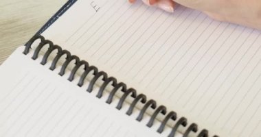 ESG konsepti. Üst görünüm, kamera ahşap masanın üzerinde yavaşça hareket ediyor, hangi dizüstü bilgisayar, tablet, not defteri, genç kadın not defterine yazı yazıyor, Çevresel Sosyal ve Kurumsal Yönetim planları