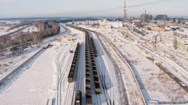 Kış mevsiminde, istasyonda vagonlara kömür doldurulur. Hava manzaralı Uhd 4k yük treni vagonları ve kömürlü ayakta duran tren.