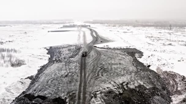 Vista dall'alto su lavori stradali in inverno. Impianti pesanti per la costruzione di strade in campagna in inverno. Vista Sopra su lavori stradali invernali — Video Stock